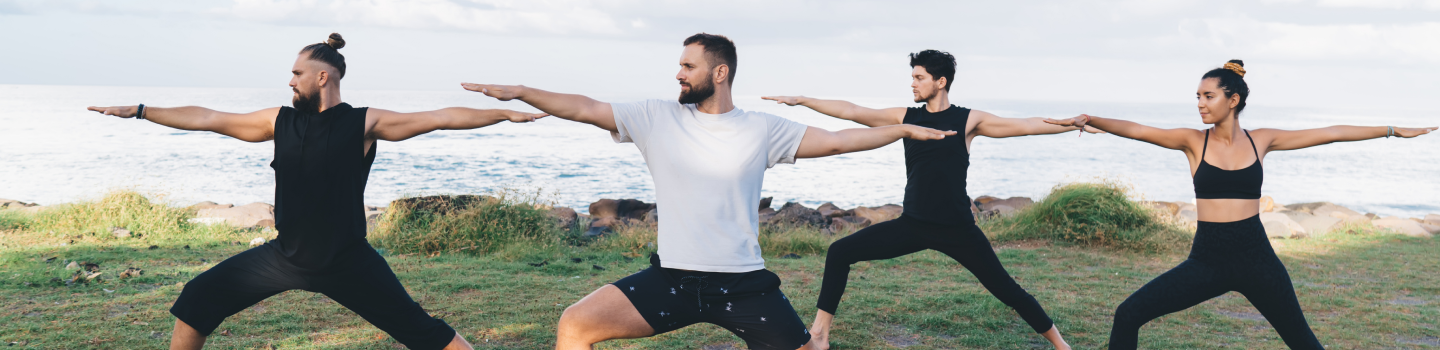 A group of people practicing yoga on the beach as part of the Shakti Kriya course, led by Art of Living