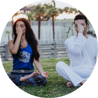 A smiling man with curly hair, hands on his head, expressing joy and reduced anxiety as part of the Art of Living Shakti Kriya program