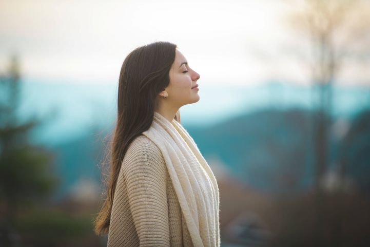 Woman enjoying deep breaths and feeling less cortisol and more serotonin.