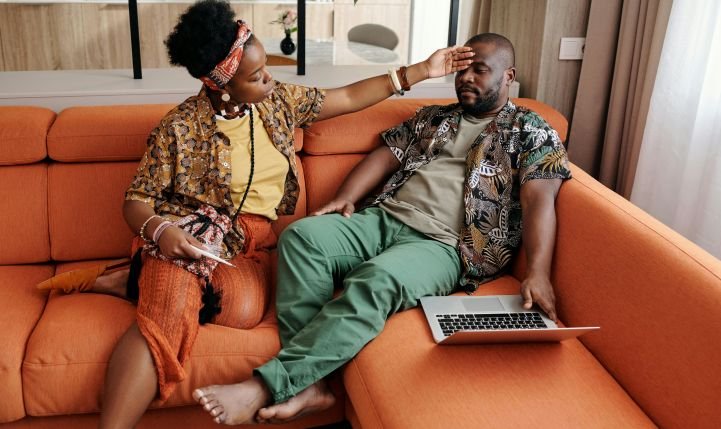 A woman checks the temperature and immune system of a man feeling unwell and sleep-deprived.