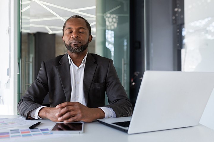Calm professional taking a mindful breathing break to boost productivity during workday