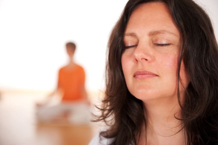 A woman taking a deep breath on an Art of Living Part 1 Course.