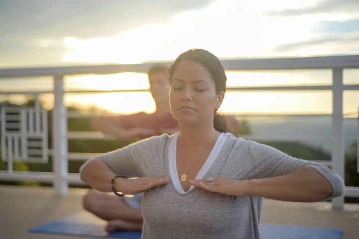 Two people practicing SKY Breath Meditation outside for anxiety reduction.