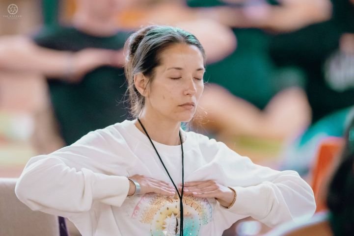 A woman practicing SKY Breath Meditation for reduced stress.