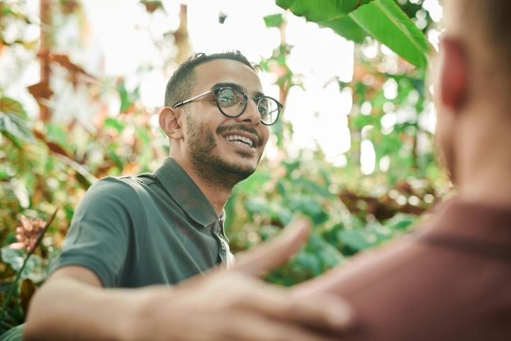 A man smiling and demonstrating self-confidence and positive self-esteem as he greets another.