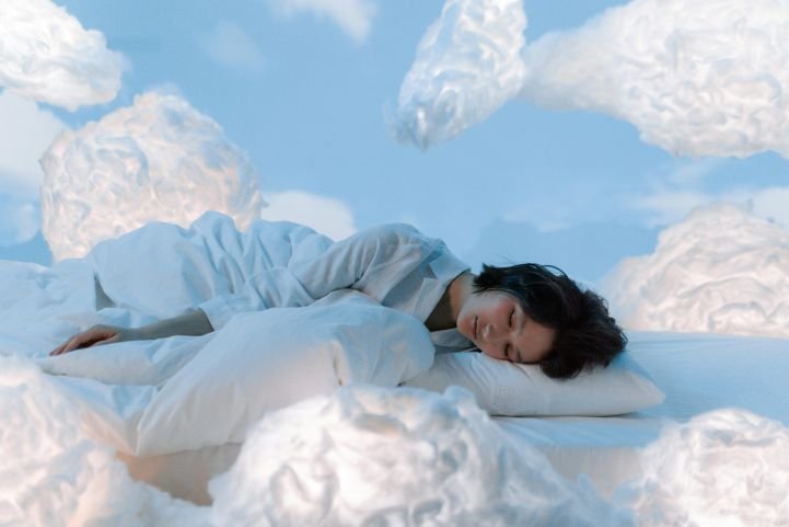 A young woman is asleep in the clouds, experiencing quality sleep.