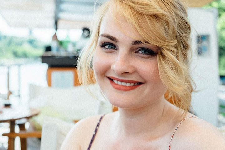 A young woman beaming with positivity and psychological well-being.