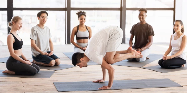Một người đàn ông đang tập yoga trong một căn phòng sáng sủa, tượng trưng cho sức mạnh nội tâm và sự tự khám phá bản thân dành cho mọi lứa tuổi.