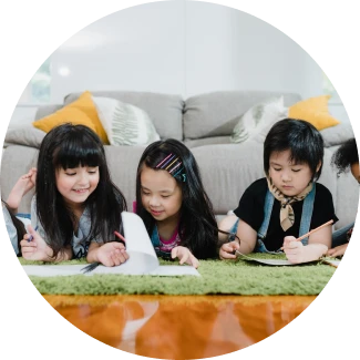 Các em nhỏ đang vẽ và tô màu tại một chiếc bàn, thể hiện các kỹ năng sống ART Excel của tổ chức The Art of Living.