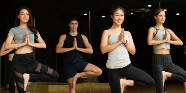 Một nhóm người đang thực hành các tư thế yoga nâng cao trong chương trình Sri Sri Yoga Deep Dive.
