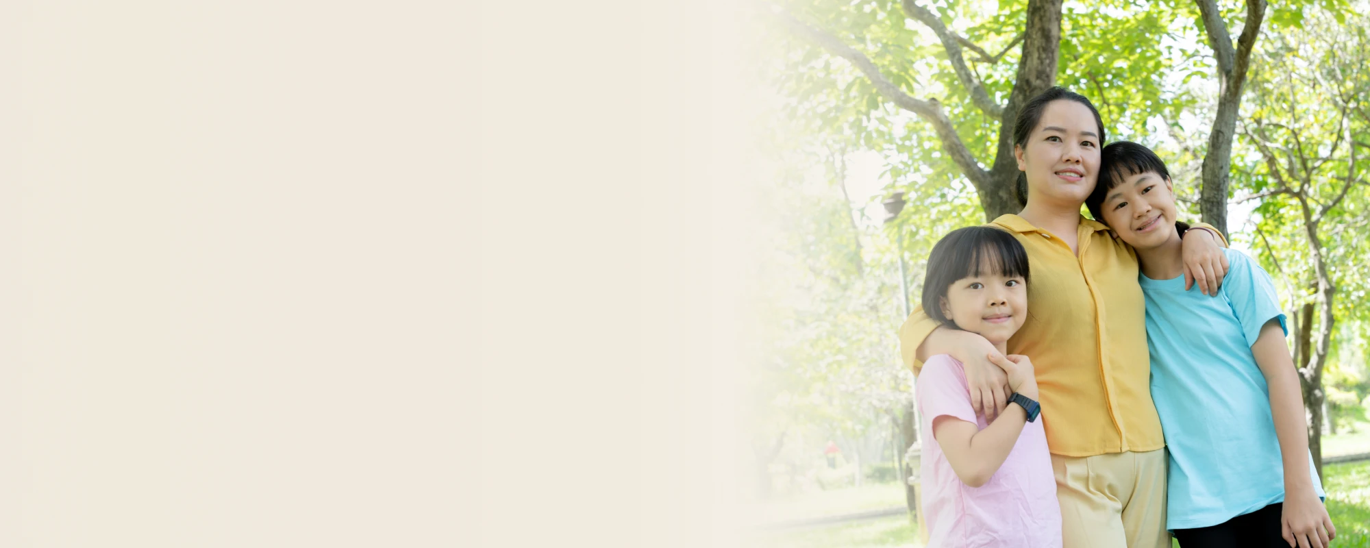 Một người mẹ đứng bên cạnh con trai và con gái của mình, vòng tay ôm lấy cả hai đứa trẻ.