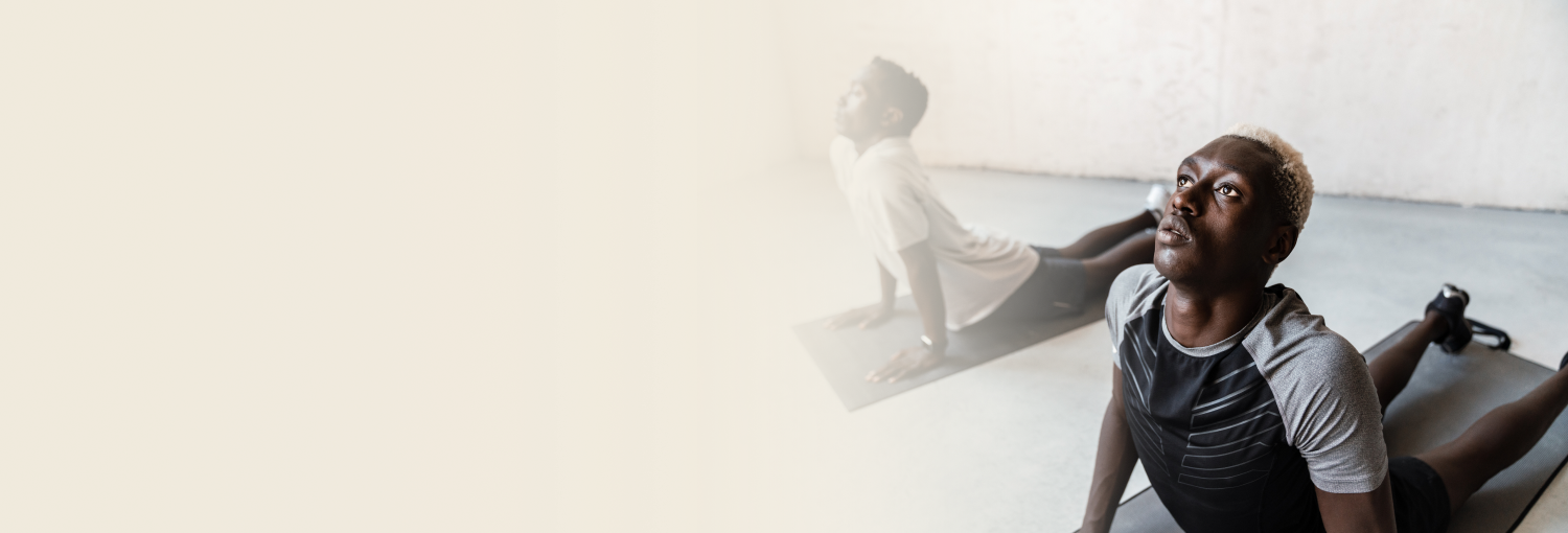 Two young African men performing yoga in a yoga studio