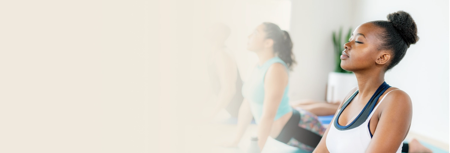 Participants in yoga pose participating in Happiness Program