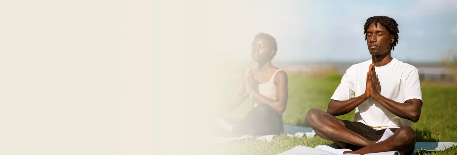 Group of people in sports wear practicing meditation in outdoor space