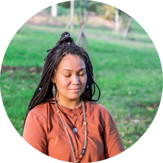 Woman in meditating in grass field during silence retreat