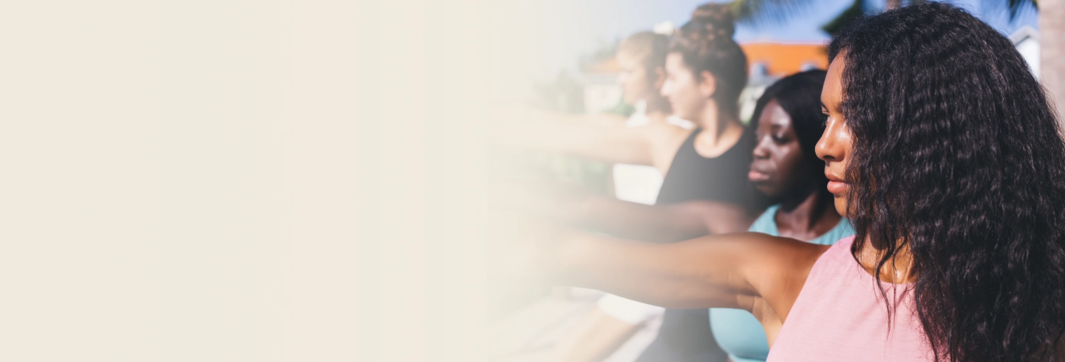 A group of young women practicing yoga in a bright room, symbolizing inner strength and self-discovery for all ages