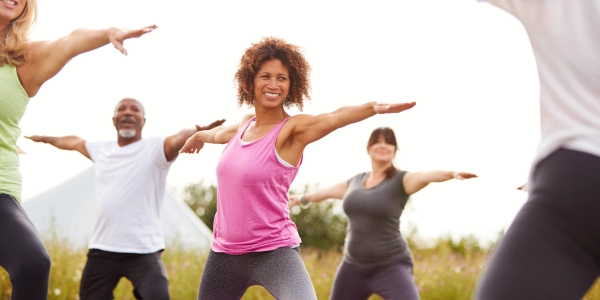 Group of people practicing yoga in an outdoor space symbolizing inner strength and self-discovery for all ages