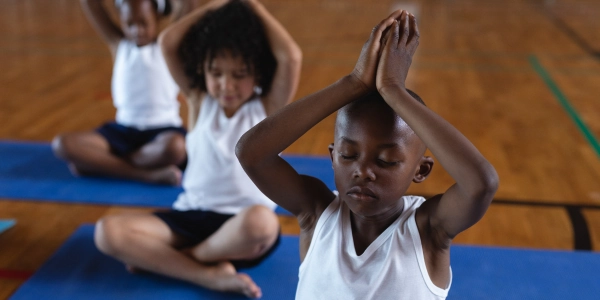 Young participant practicing meditation posture during ART EXCEL session in a mindful learning space