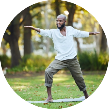 A bearded man performing yoga asana in a lawn area